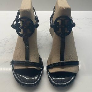 Tory Burch black patent medallion T-strap sandals.